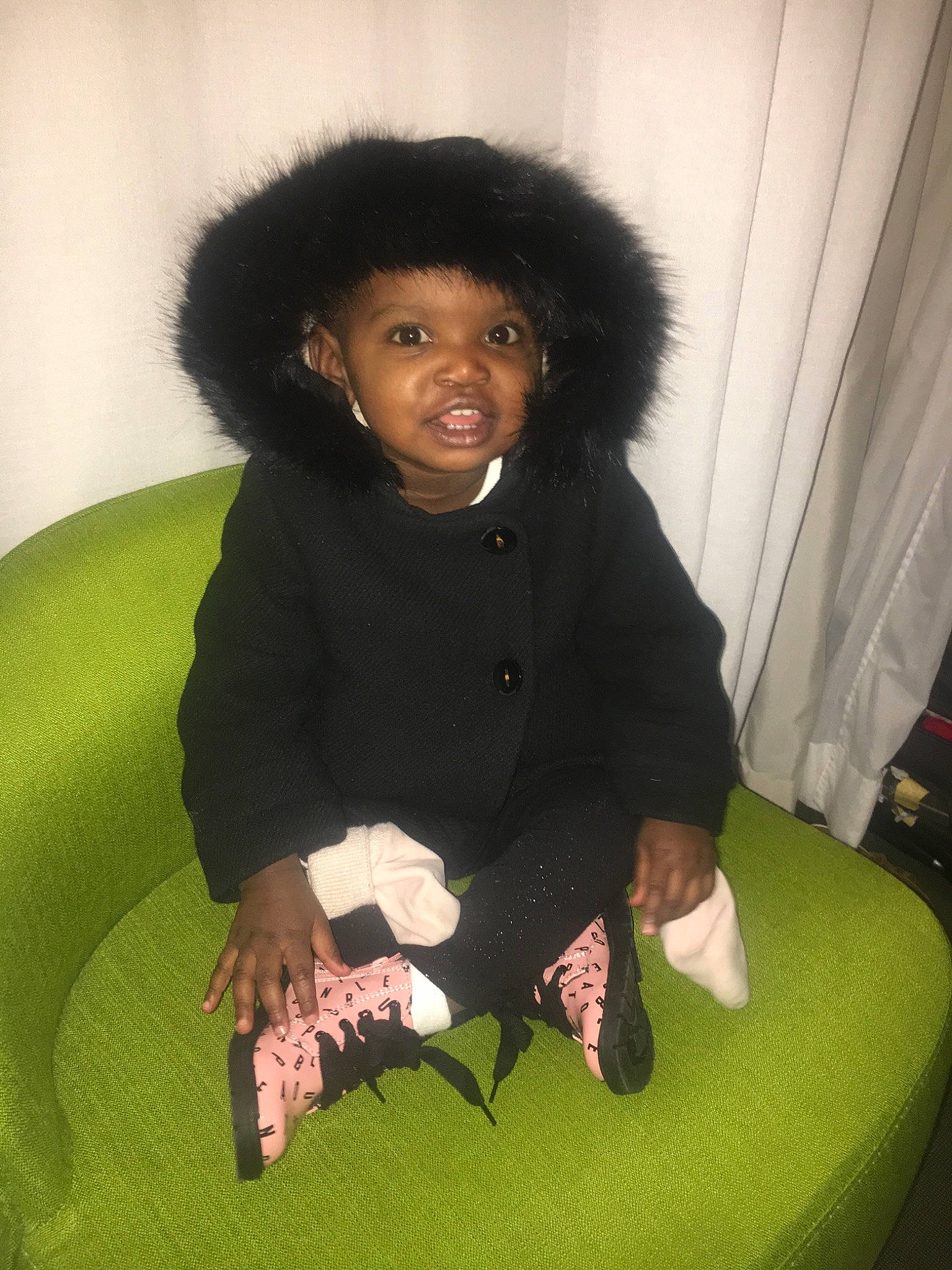 Théana participe au concours pour gagner de l'argent avec cette photo : black_hair, child, fun, fur, girl, hair, joy, outerwear, person, sitting, smile, textile, toddler