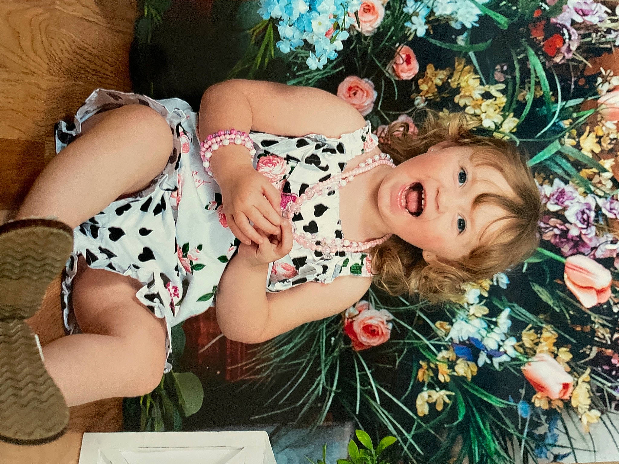 Harper is registered to the contest to win money with this photo: blond, brown_hair, floral_design, flower, flower_arranging, grass, happy, hat, human_leg, long_hair, pattern, person, petal, pink, plant, rose, summer, thigh, toy, tree