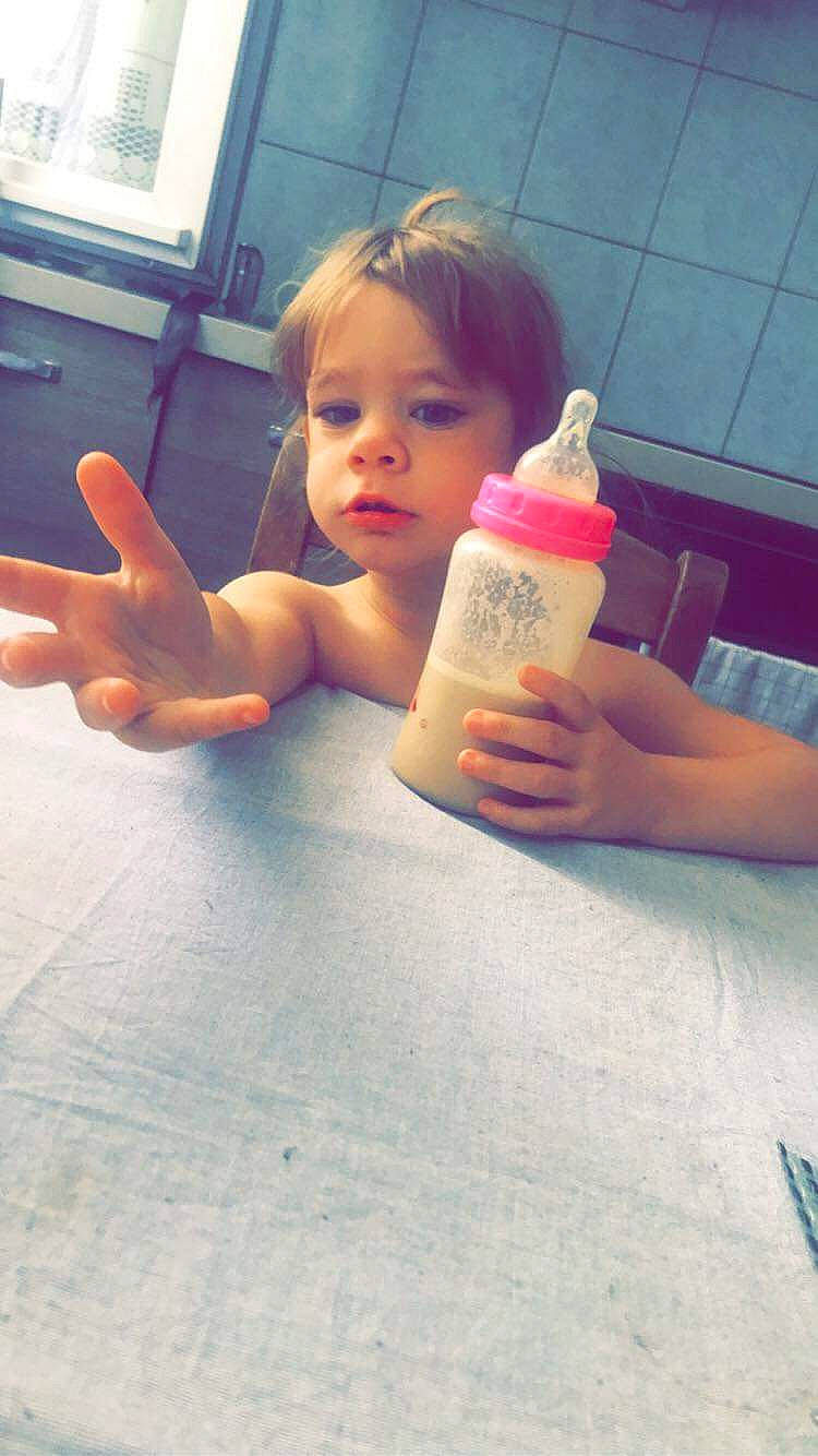 Tyla participe au concours pour gagner de l'argent avec cette photo : bottle, cloud, drinkware, finger, flooring, gesture, hair, head, human_body, joint, leg, mouth, nail, person, plastic_bottle, skin, table, thumb, tints_and_shades, toddler