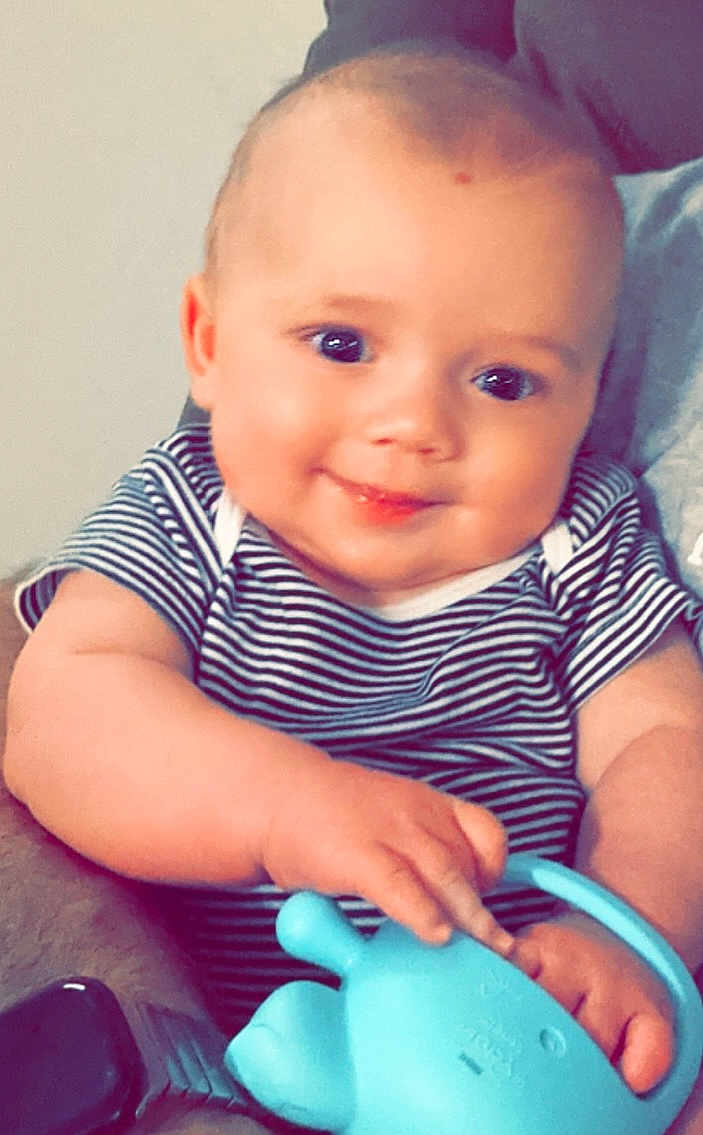 Bryson is registered to the contest to win money with this photo: baby, bodypart, clothing, couch, cup, cushion, face, furniture, happy, head, homedecor, laughing, newborn, person, photography, portrait, pottery, sitting, smile, t_shirt