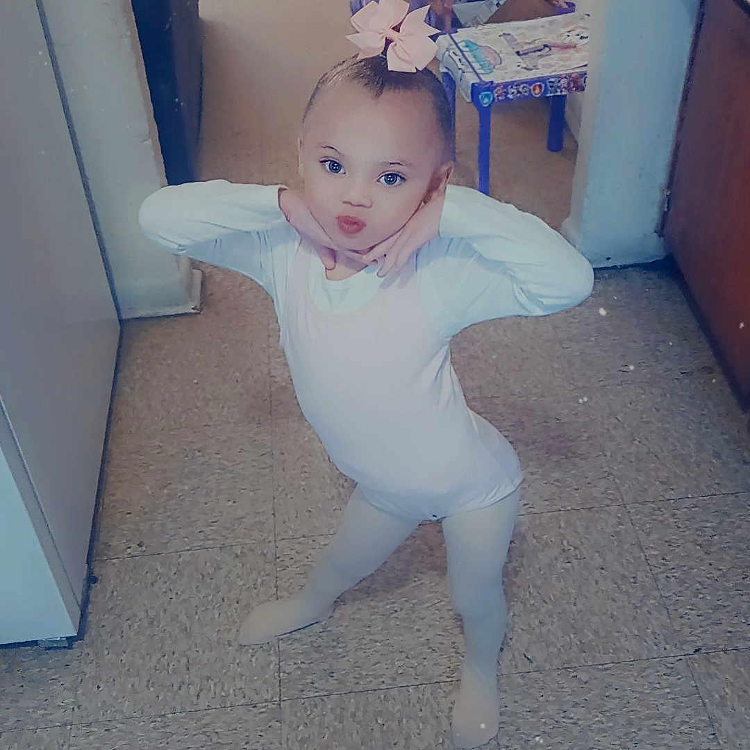 Yakira joined the competition — help win amazing prizes! ballet, bow, child, clothing, cute, dance, floor, floor_tile, furniture, hallway, home, indoor, leotard, person, playful, posing, smile, tights, toy, young