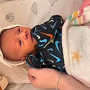 Wynter is registered to the contest to win money with this photo: newborn, baby, infant, blanket, headband, hand, clothing, onesie, pattern, face, skin, sleepwear, comfort, soft, bed, rest, cute, small, lying_down, cozy