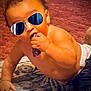 Eric joined the competition — help win amazing prizes! baby, child, indoor, carpet, toy, crawling, shirtless, diaper, hand, face, sunglasses, cool, playful, chewing, infant, young_child, floor, pattern, cute, portrait