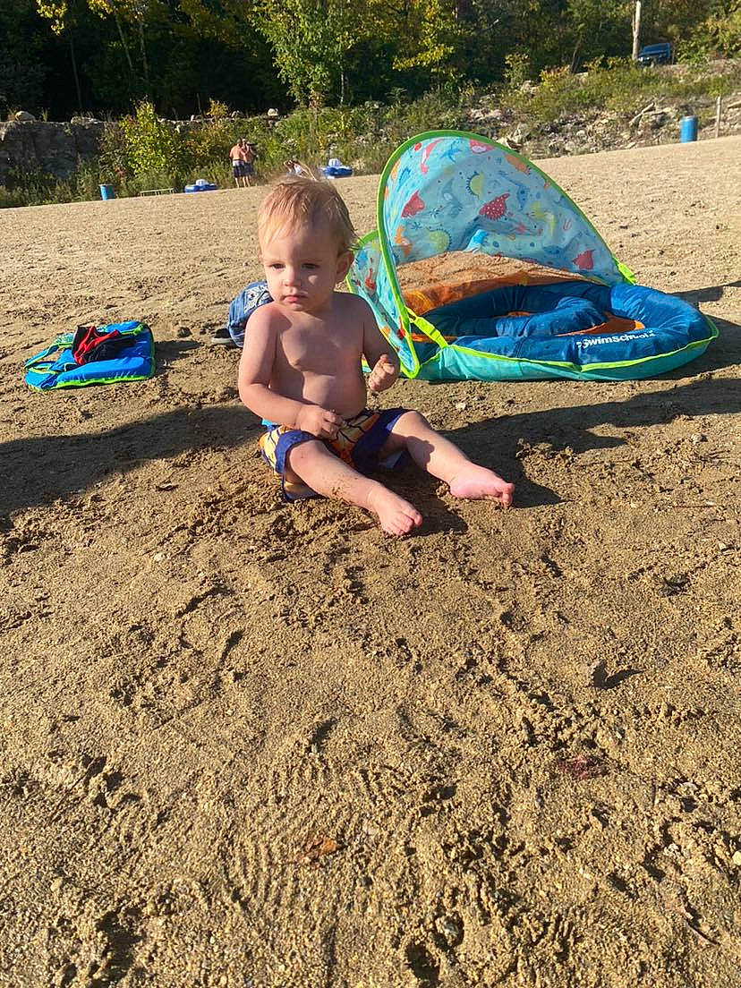 Salem is registered to the contest to win money with this photo: beach, boats_and_boating_equipment_and_supplies, camping, child, coast, fun, grass, landscape, leisure, ocean, outdoor_furniture, outdoor_play_equipment, people_in_nature, person, play, recreation, sand, shade, sitting, soil