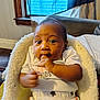 Ry'Lynn is registered to the contest to win money with this photo: baby, infant, child, white_shirt, star_pattern, pants, fluffy_seat, indoor, window, blue_curtain, wooden_window_frame, carpet, floor, couch, blanket, person, face, hand, expression, home