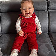 Luna participe au concours pour gagner de l'argent avec cette photo : baby, child, comfortable, corduroy, couch, cute, floral_pattern, gray_couch, hair_tufts, happy, indoor, infant, long_sleeve_shirt, person, portrait, red_overalls, sitting, smiling, socks, young_child