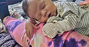 Tucker is registered to the contest to win money with this photo: baby, bed, bedroom, blanket, clothing, cushion, face, furniture, glove, head, homedecor, indoors, newborn, person, photography, portrait, purple, quilt, room, sleeping