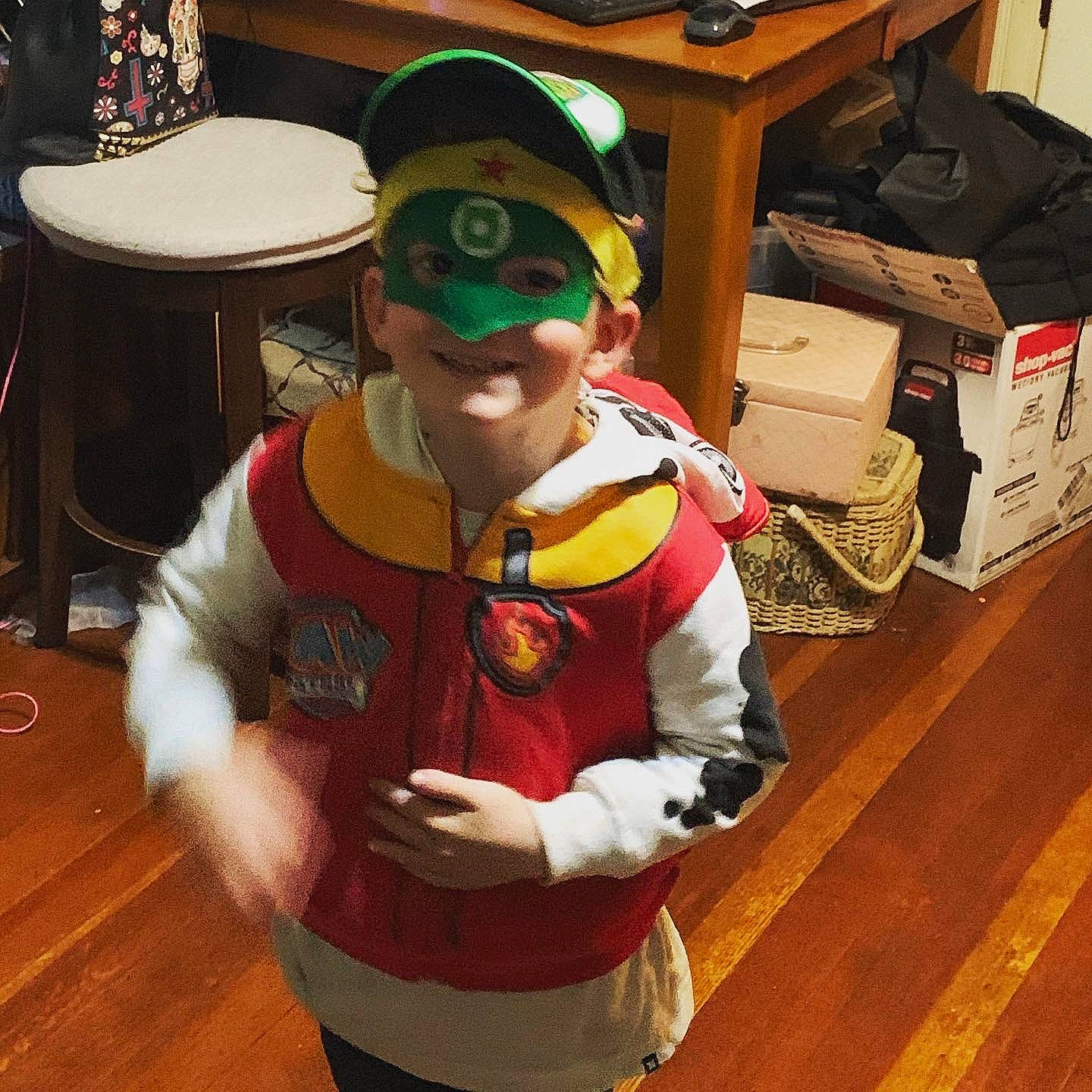 Bennett is registered to the contest to win money with this photo: cap, carton, child, costume_hat, event, eyewear, flooring, fun, glove, goggles, happy, hardwood, holiday, joy, person, personal_protective_equipment, shipping_box, smile, sunglasses, table