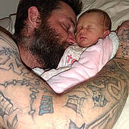 Karoleena is registered to the contest to win money with this photo: arm, baby, beard, bed, blanket, close_up, cozy, cuddle, face, family, indoor, love, man, newborn, person, pink_clothing, resting, skin, sleeping, tattoos