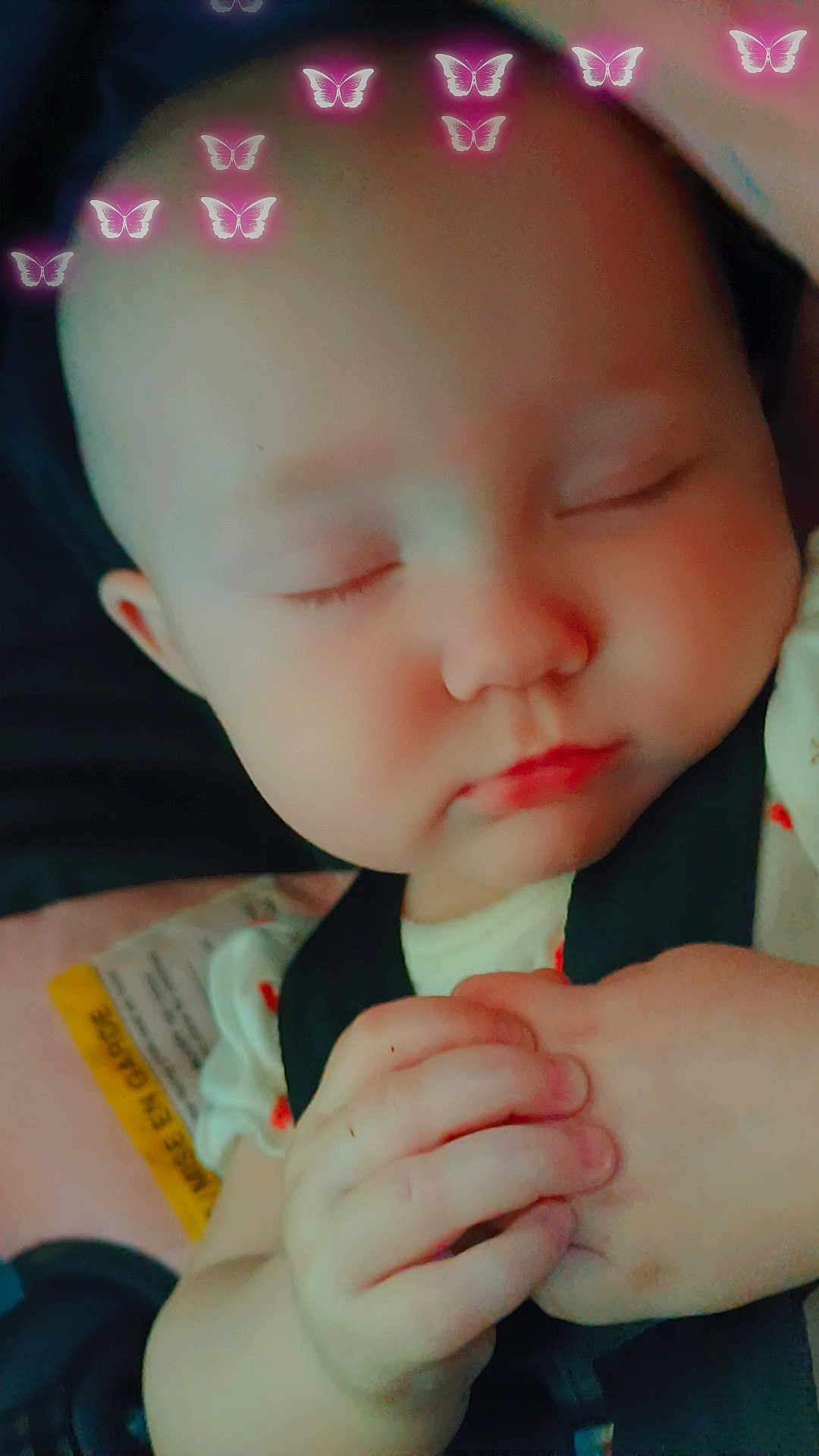 Karoleena is registered to the contest to win money with this photo: adorable, baby, butterfly_filter, car_seat, child, clasped_hands, closeup, cute, expression, face, hands, head, infant, peaceful, pink_butterflies, portrait, resting, sleeping, soft_lighting, young