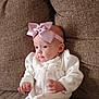 Karoleena joined the competition — help win amazing prizes! baby, infant, bow, headband, white_outfit, pink_spots, couch, brown_couch, seated, curious, wide_eyes, hands, soft_texture, indoor, child, cute, portrait, cozy, apparel, young_child