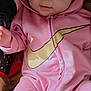 apparel, baby, blanket, child, clothing, cozy, cute, expression, face, hood, hoodie, indoor, infant, looking, pink_clothing, portrait, sitting, smile, soft_lighting, young_child