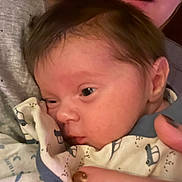 Charles participe au concours pour gagner de l'argent avec cette photo : adult, baby, blanket, blue, closeup, clothing, cozy, eyeball, face, hair, hand, holding, infant, mouth, nail_polish, newborn, pattern, person, skin, white