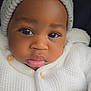 Axel is registered to the contest to win money with this photo: baby, beanie, button, child, closeup, cozy, cute, expression, eyelashes, face, headwear, indoors, infant, knitwear, person, portrait, skin, sweater, warm_clothing, young