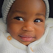 Axel is registered to the contest to win money with this photo: baby, child, face, smile, knitwear, beanie, warm_clothing, closeup, portrait, cute, infant, eyelashes, button, cozy, soft_texture, winter_wear, baby_face, happy, young, cute_expression