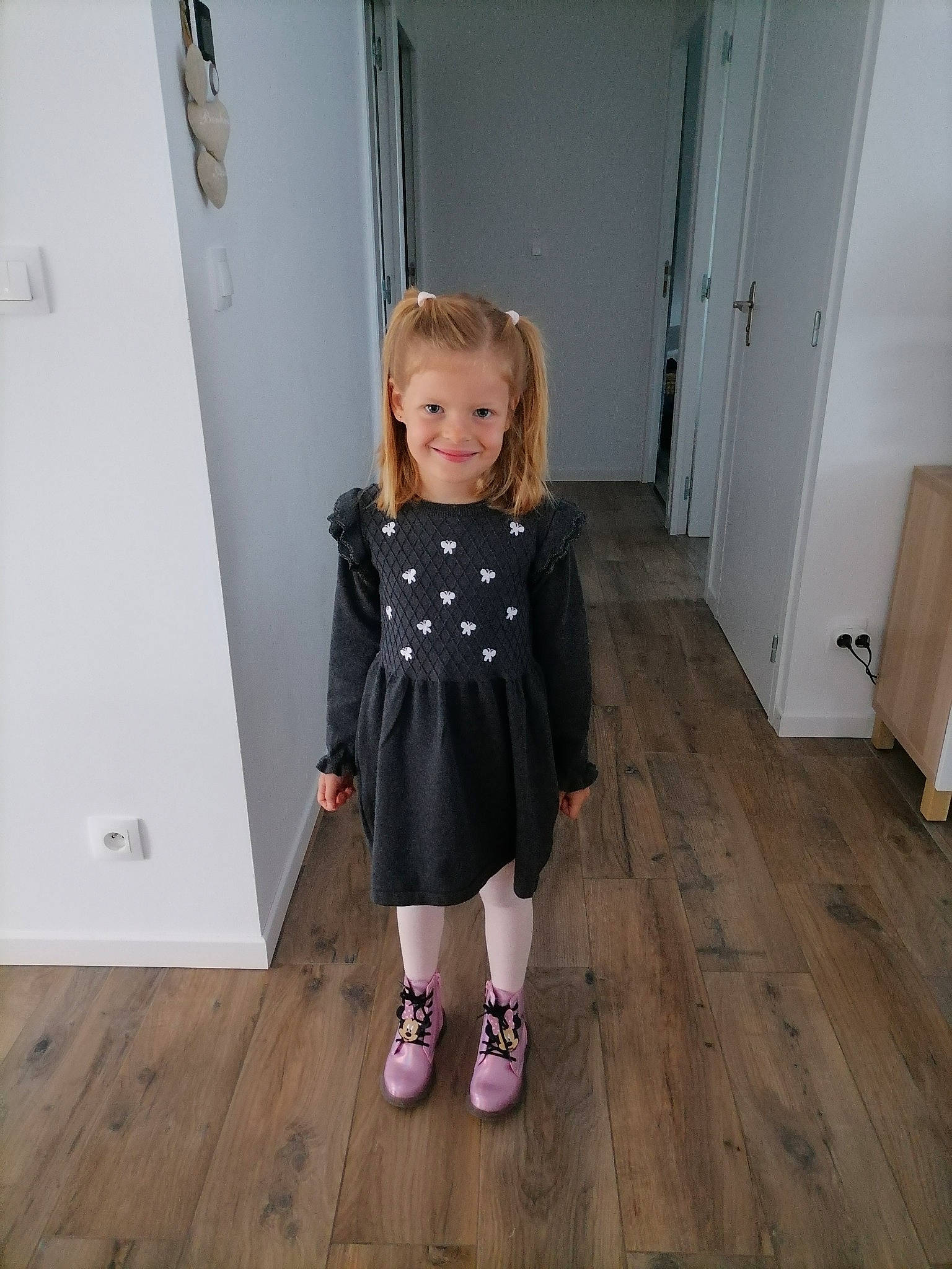 Milla participe au concours pour gagner de l'argent avec cette photo : baby_toddler_clothing, door, dress, event, floor, flooring, hardwood, human_leg, joy, laminate_flooring, pattern, person, plank, sleeve, smile, standing, toddler, varnish, waist, wood