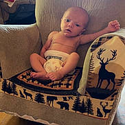 Stetson joined the competition — help win amazing prizes! baby, infant, armchair, blanket, diaper, wood_floor, indoors, furniture, child, nature_pattern, animal_print, relaxed, portrait, cute, small, person, cozy, home, lamp, window