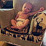 baby, infant, armchair, blanket, diaper, wood_floor, indoors, furniture, child, nature_pattern, animal_print, relaxed, portrait, cute, small, person, cozy, home, lamp, window