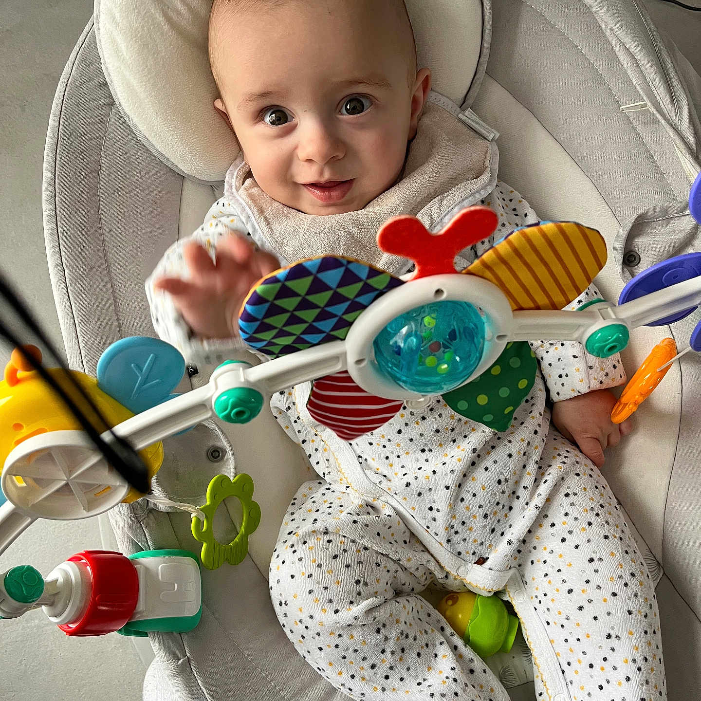 Timeo participe au concours pour gagner de l'argent avec cette photo : baby, baby_chair, child, colorful_toys, comfortable, curious, cute, expression, face, foot, hand, happy, indoor, infant, onesie, person, playful, polka_dot, sitting, toy_bar