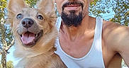 Freya Diamond Ayala is registered to the contest to win money with this photo: man, dog, outdoor, park, smiling, happy, tank_top, pet, canine, nature, tree, greenery, sunlight, leaves, summer, casual, beard, closeup, holding, daytime