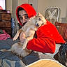Freya Diamond Ayala is registered to the contest to win money with this photo: person, dog, indoor, hugging, red_hoodie, furniture, fan, bed, blanket, wooden_chair, drawer, television, clutter, casual, pet, relaxed, light, cozy, portrait, companion