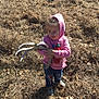 antler, bottle, casual_clothing, child, curious, daylight, dry_grass, fall, field, grass, jeans, leaves, nature, outdoor, person, pink_hoodie, shadow, sneakers, sunlight, young_child