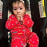 Five is registered to the contest to win money with this photo: afro_hair, baby, bright_colors, car_seat, child, closeup, cozy, curious, cute, expression, hand_in_mouth, headband, indoor, infant, patterned_clothing, portrait, red_pajamas, sitting, warning_label, young_child