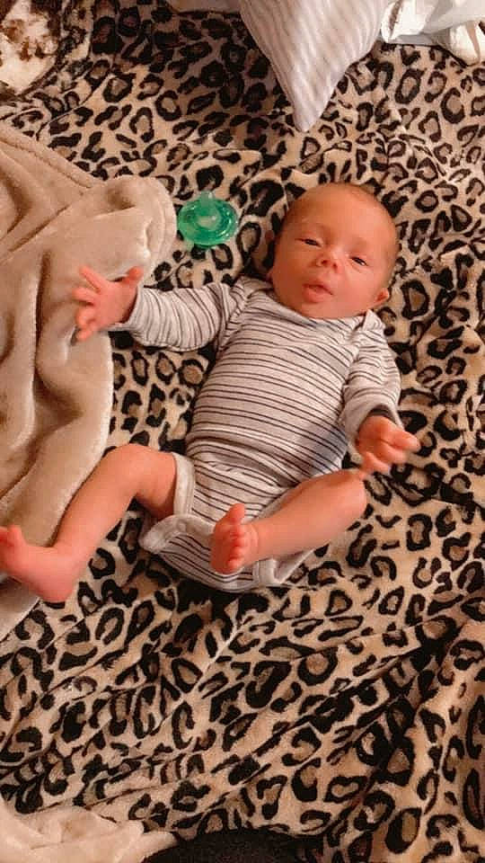 Jaxtyn joined the competition — help win amazing prizes! baby, baby_toddler_clothing, cheek, child, comfort, finger, floor, flooring, foot, human_leg, linens, orange, pattern, person, pink, skin, textile, thigh, toddler, toy