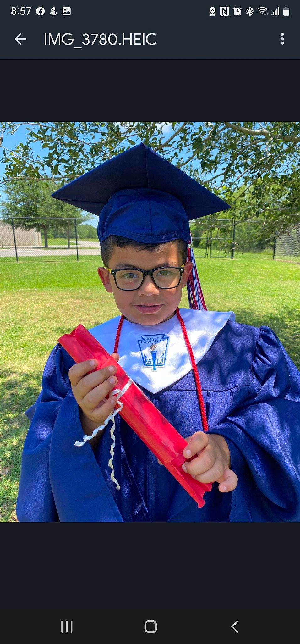 Ezbyn is registered to the contest to win money with this photo: academic_dress, academic_institution, electric_blue, event, eyewear, fashion_accessory, fun, glasses, graduation, grass, hat, headgear, mortarboard, outerwear, person, phd, plant, scholar, tree, uniform
