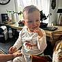 Mensïo participe au concours pour gagner de l'argent avec cette photo : toddler, child, kitchen, white_clothing, fox_print, curtains, plant, clock, hand, table, countertop, milk_bottle, coffee_machine, blanket, toy, window, natural_light, pensive, indoor, person