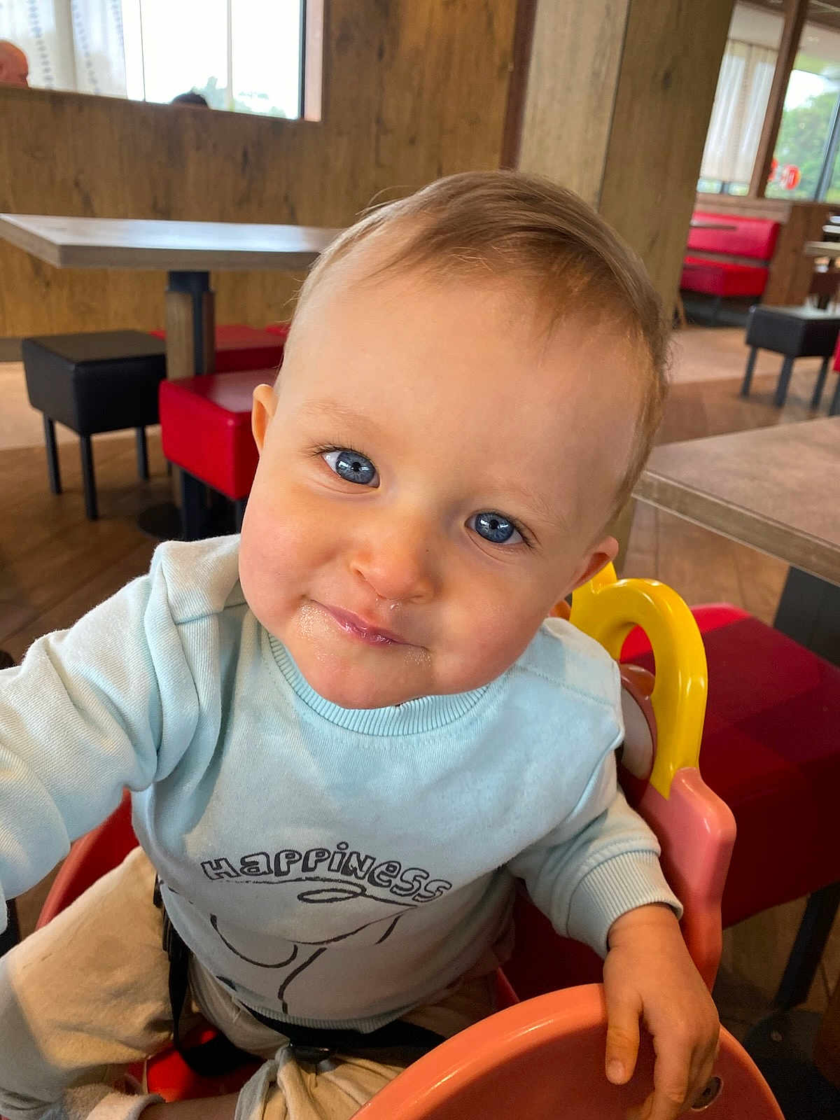 Mensïo participe au concours pour gagner de l'argent avec cette photo : toddler, child, blue_eyes, high_chair, sweater, happiness, smile, indoor, restaurant, table, chair, furniture, wooden_wall, colorful, cute, portrait, baby, face, person, happy