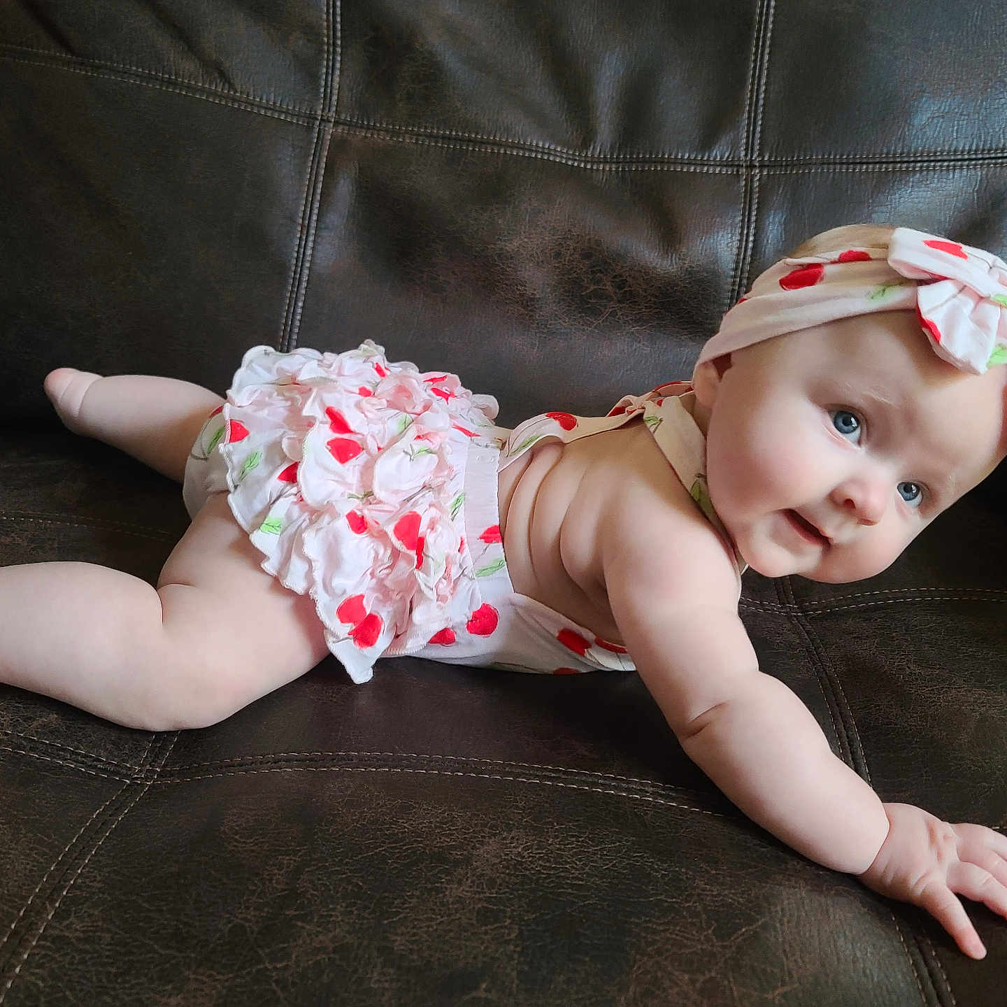 Charlotte is registered to the contest to win money with this photo: baby, bodypart, bonnet, cap, clothing, couch, crawling, diaper, dress, face, finger, furniture, hand, hat, head, newborn, person, photography, portrait, sitting