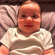 Harley joined the competition — help win amazing prizes! baby, bed, cheeks, child, cute, expression, eyes, face, human, indoors, infant, lying_down, onesie, pillow, portrait, skin, smile, soft_lighting, tongue, young