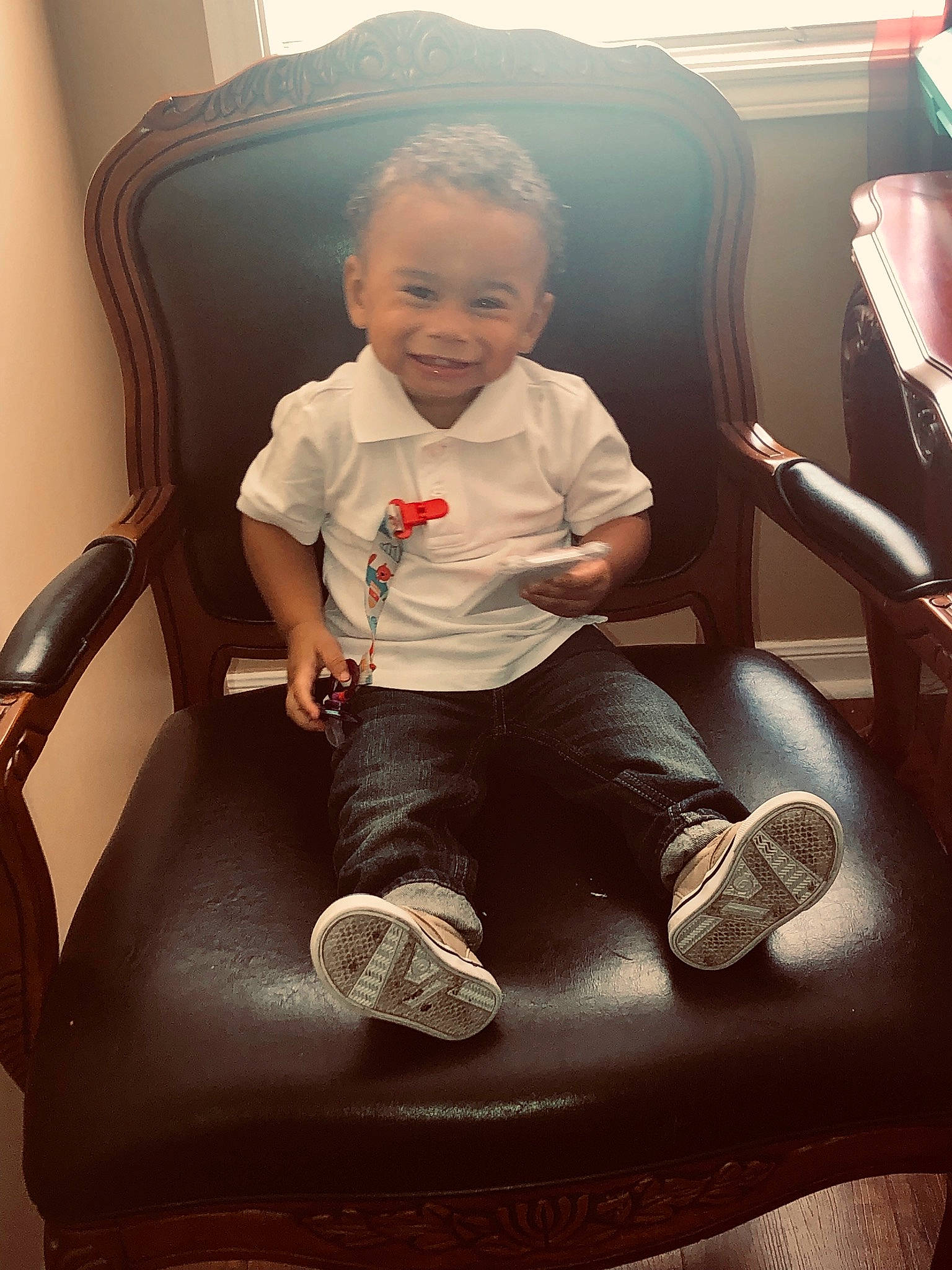Tylen is registered to the contest to win money with this photo: baby, chair, child, comfort, cool, electronic_device, fun, furniture, joy, leg, person, play, shoe, sitting, toddler
