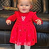 bible, book, child, cute, floor, furniture, girl, happy, holiday_dress, home, indoor, innocent, leather_couch, pigtails, portrait, red_dress, smiling, standing, toddler, white_tights
