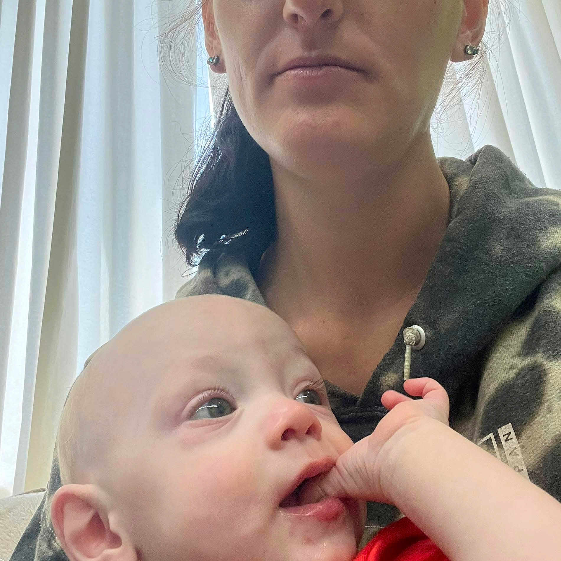 Daniel is registered to the contest to win money with this photo: baby, infant, woman, adult, face, portrait, hand, curious, indoor, curtain, clothing, hoodie, skin, expression, closeup, person, parent, child, light, natural_light