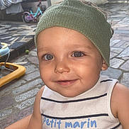 Milann participe au concours pour gagner de l'argent avec cette photo : toddler, child, smiling, headband, blue_eyes, striped_clothing, outdoor, courtyard, bicycle, laundry, stone_floor, door, gate, person, casual_wear, summer, cute, portrait, happy, baby