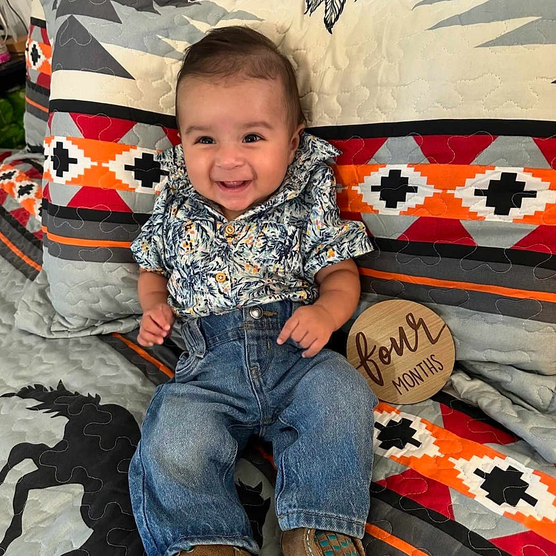Jaxson is registered to the contest to win money with this photo: baby, bed, bedroom, clothing, couch, cushion, face, footwear, furniture, head, homedecor, indoors, jeans, pants, person, photography, portrait, quilt, shoe, sitting