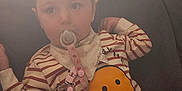 Everleigh joined the competition — help win amazing prizes! baby_bib, casual, child, clothing, comfort, couch, cute, face, hair, indoor, pacifier, person, relaxed, seated, smiley_face, soft_light, striped_shirt, toddler, wild_hair, young_child