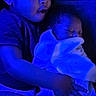 child, baby, infant, sleeping, holding, blue_light, blanket, clothing, portrait, indoor, young_child, curious, peaceful, tender, family, sibling, closeup, skin, face, person