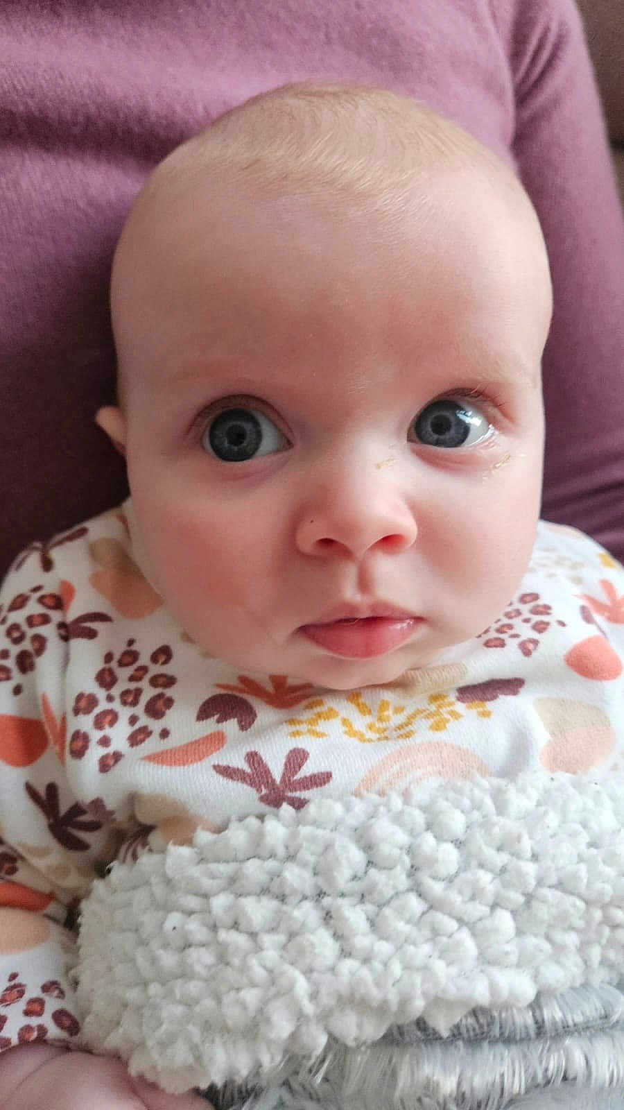 Maëve participe au concours pour gagner de l'argent avec cette photo : baby, blanket, child, closeup, clothing, curious, cute, expression, eyes, face, head, indoor, infant, patterned_outfit, person, portrait, skin, soft_texture, warm, young