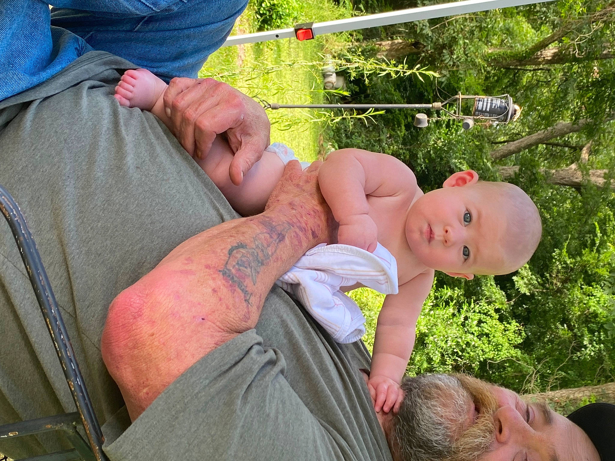 Annamarie is registered to the contest to win money with this photo: abdomen, baby, barechested, chest, elbow, fun, grass, hand, happy, human_leg, leisure, muscle, people_in_nature, person, plant, shorts, t_shirt, thigh, toddler, tree