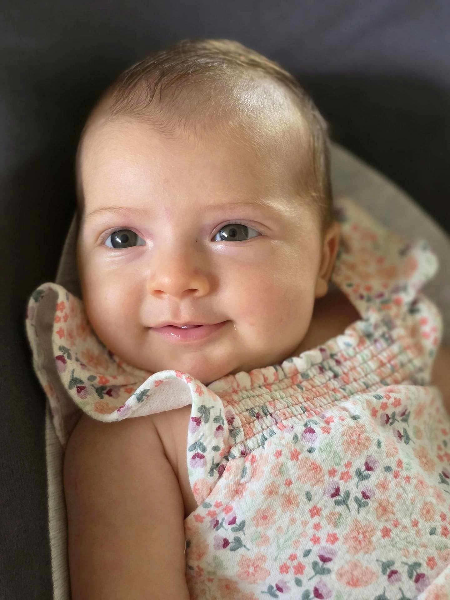 Alicia a rejoint le concours — aidez-le/la à gagner de superbes lots ! baby, infant, face, smile, eyes, skin, clothing, dress, floral_pattern, ruffles, closeup, portrait, cute, child, young, soft_light, indoors, happy, person, sitting