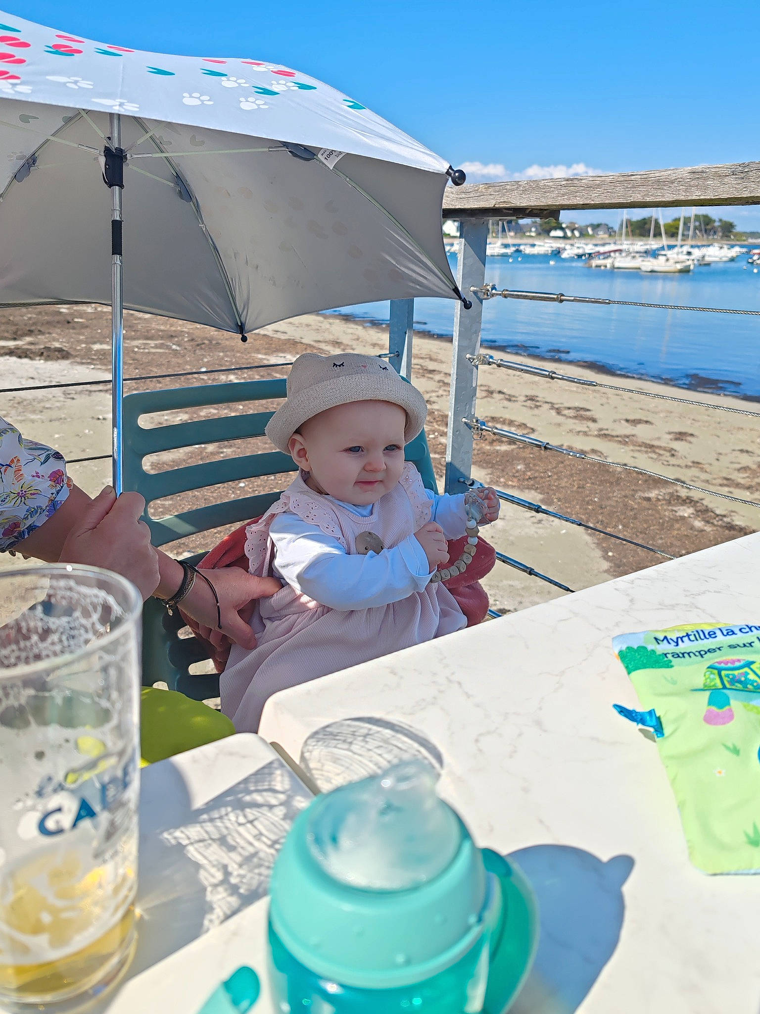 Maëline a rejoint le concours — aidez-le/la à gagner de superbes lots ! chair, cup, dishware, drink, drinkware, event, hat, leisure, person, plastic_bottle, plate, recreation, serveware, sky, t_shirt, table, tableware, toddler, travel, water