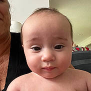 Dana Marylynn is registered to the contest to win money with this photo: baby, person, indoor, face, skin, expression, curious, holding, adult, close_up, head, shoulders, human, portrait, room, light, couch, blanket, casual, family