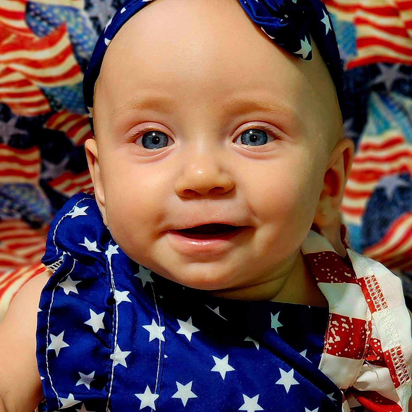 Kaisley Hatfield is registered to the contest to win money with this photo: american_flag, baby, background, blue_eyes, celebration, child, closeup, clothing, colorful, cute, fabric, face, happy, headband, holiday, infant, pattern, portrait, smile, stars
