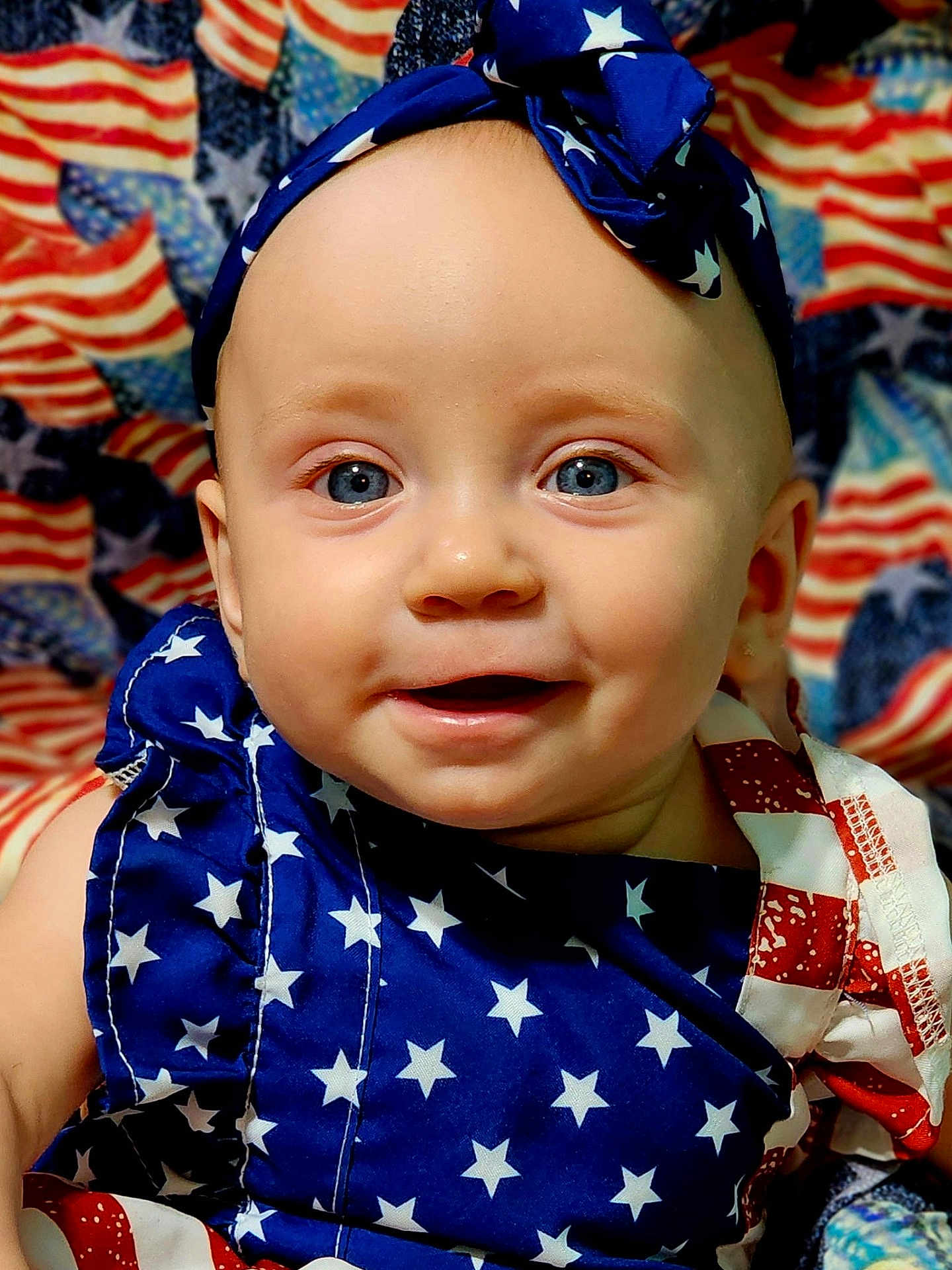 Kaisley Hatfield is registered to the contest to win money with this photo: baby, child, face, smile, blue_eyes, headband, clothing, stars, american_flag, background, portrait, closeup, cute, infant, happy, pattern, fabric, colorful, celebration, holiday