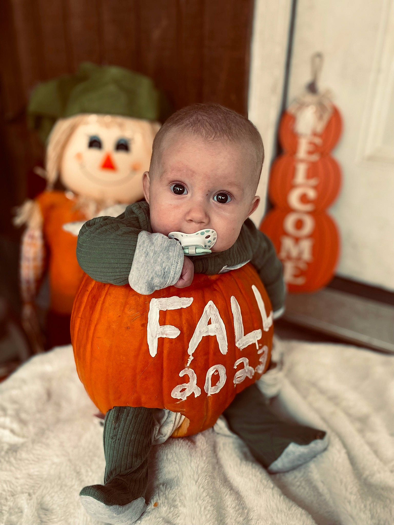Lincoln is registered to the contest to win money with this photo: baby, baby_toddler_clothing, calabaza, child, doll, figurine, flooring, fur, happy, hat, lawn_ornament, orange, peach, person, plush, sitting, sleeve, stuffed_toy, toddler, toy
