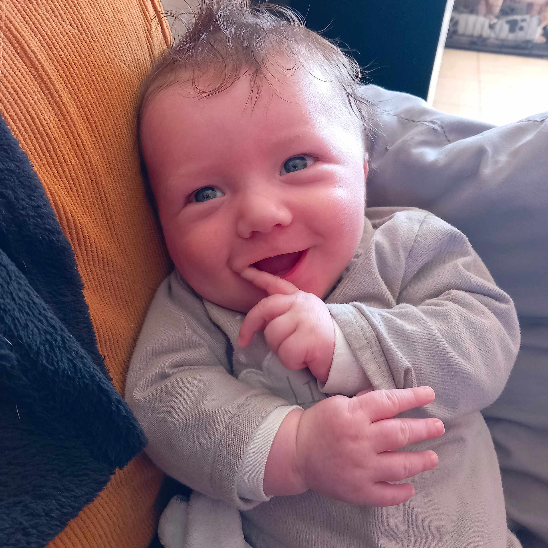 Emilio participe au concours pour gagner de l'argent avec cette photo : baby, babylaughing, bodypart, clothing, couch, face, finger, furniture, hand, happy, head, knitwear, laughing, mouth, newborn, person, photography, portrait, smile, sweater