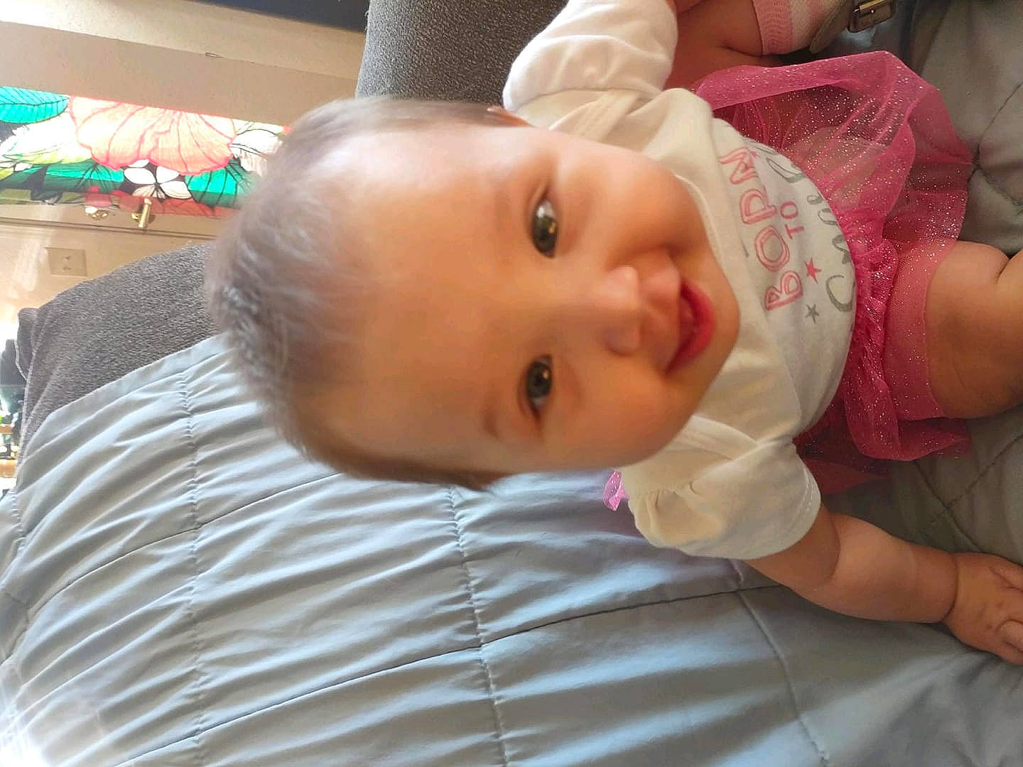 Justice is registered to the contest to win money with this photo: baby, baby_toddler_clothing, cheek, child, dress, eyebrow, eyelash, flooring, fun, happy, hat, human_body, iris, lip, mouth, nose, person, room, skin, smile